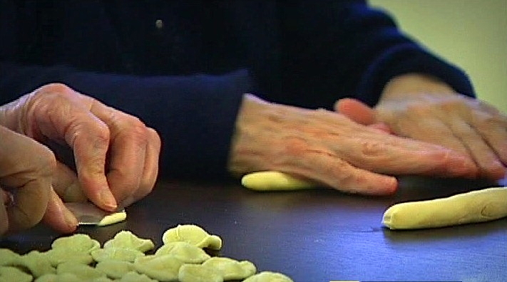 The photo illustrates the resumption of manual skills in making pasta by hand for two elderly patients.